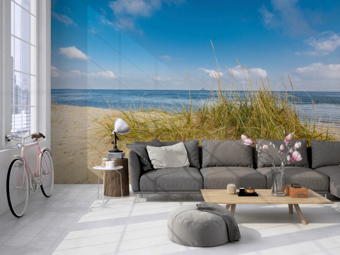 Die Fototapete Sylt, Düne am Meer bei Sonnenschein auf einer großen Wand im Loft tapeziert. Die Fototapete Sylt, Düne am Meer bei Sonnenschein wird individuell auf Deine Wand angepasst.
