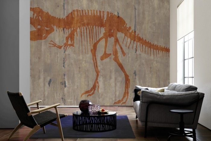 Im Wohnzimmer die Design-Fototapete T-Rex Skelett auf Beton, Artwork auf einer großen Wand tapeziert. Die Design-Fototapete T-Rex Skelett auf Beton, Artwork ist als Vlies-Fototapete im Wohnzimmer leicht zu tapezieren.