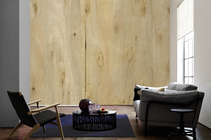 Im Wohnzimmer die Fototapete Holz Wand, Holzplatten auf einer großen Wand tapeziert. Die Fototapete Holz Wand, Holzplatten ist als Vlies-Fototapete im Wohnzimmer leicht zu tapezieren.