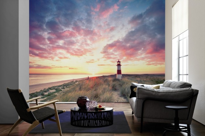 Im Wohnzimmer die Fototapete Leuchtturm von Sylt bei Sonnenaufgang auf einer großen Wand tapeziert. Die Fototapete Leuchtturm von Sylt bei Sonnenaufgang ist als Vlies-Fototapete im Wohnzimmer leicht zu tapezieren.