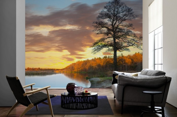 Im Wohnzimmer die Fototapete Sonnenuntergang am Waldsee, Schweden auf einer großen Wand tapeziert. Die Fototapete Sonnenuntergang am Waldsee, Schweden ist als Vlies-Fototapete im Wohnzimmer leicht zu tapezieren.