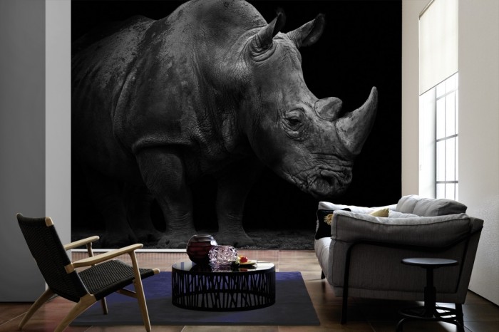 Im Wohnzimmer die Fototapete Nashorn, schwarz-weiß auf einer großen Wand tapeziert. Die Fototapete Nashorn, schwarz-weiß ist als Vlies-Fototapete im Wohnzimmer leicht zu tapezieren.