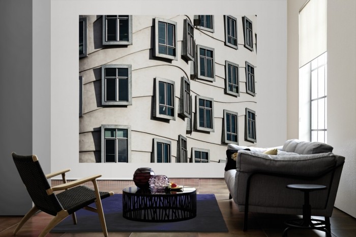 Die Fototapete Fassade Tanzendes Haus, Prag als große Bildtapete im Wohnzimmer. Als Bildtapete ist die Fototapete Fassade Tanzendes Haus, Prag ein besonderes Highlight auf Vliestapete.