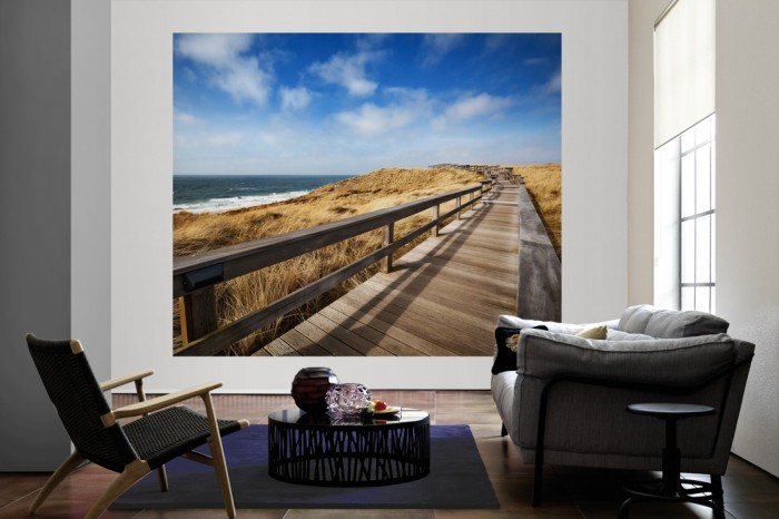 Die Fototapete Sylt, Holzsteg am Strand als große Bildtapete im Wohnzimmer. Als Bildtapete ist die Fototapete Sylt, Holzsteg am Strand ein besonderes Highlight auf Vliestapete.
