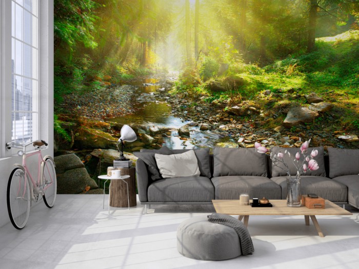 Die Fototapete Waldbach bei Sonnenschein auf einer großen Wand im Loft tapeziert. Die Fototapete Waldbach bei Sonnenschein wird individuell auf Deine Wand angepasst.